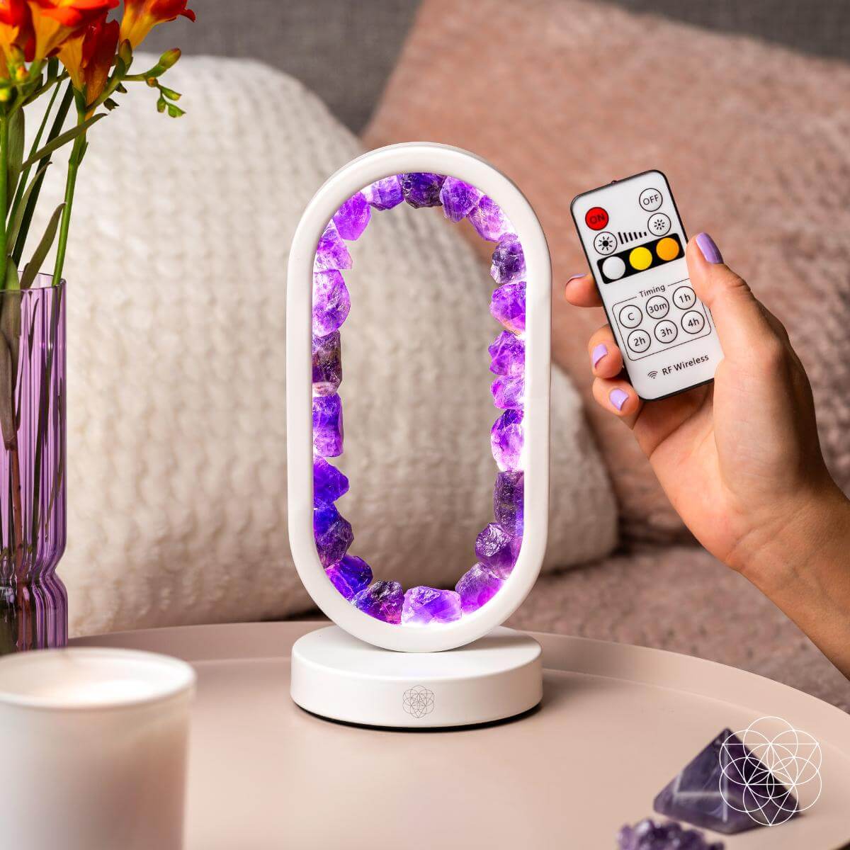 Person using the remote control beside the lit amethyst crystal arch lamp